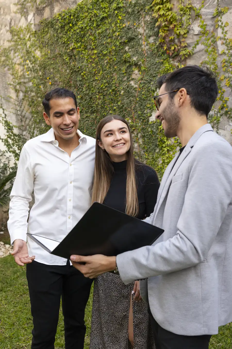 Asesor inmobiliario conversando con una pareja de clientes